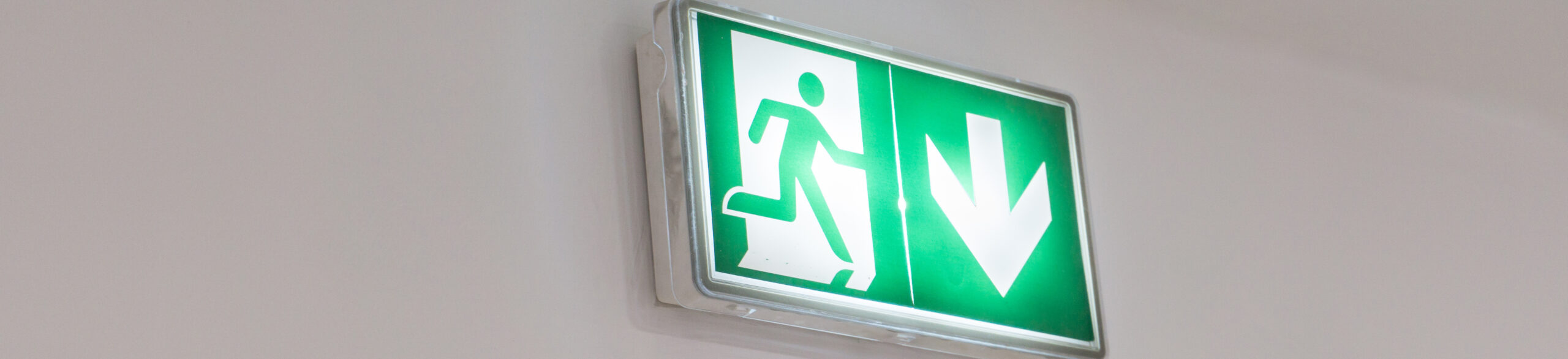 Emergency exit sign in a building glowing green